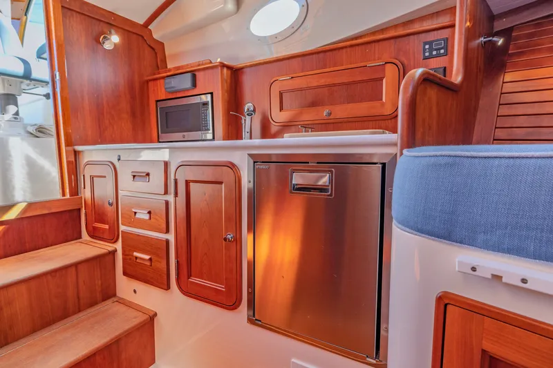 Slide: The Image of Interior of 2021 Hinckley Picnic Boat 34 MKII with wooden cabinetry and modern appliances. - 17