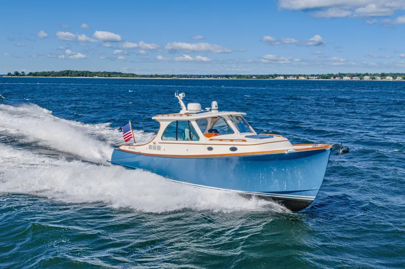 Slide: The Image of 2021 Hinckley Picnic Boat 34 MKII cruising on open water under a clear blue sky. - 4