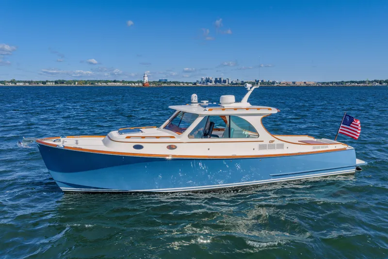 The Image of 2021 Hinckley Picnic Boat 34 MKII cruising on open water under clear blue skies. - 0
