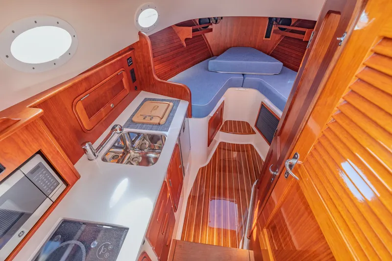 Slide: The Image of Interior of 2021 Hinckley Picnic Boat 34 MKII with wood finish and compact kitchen. - 14