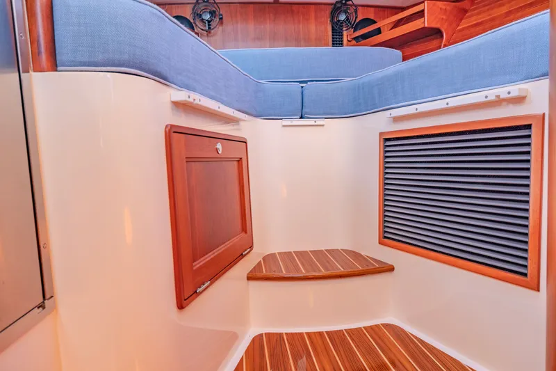 Slide: The Image of Interior of 2021 Hinckley Picnic Boat 34 MKII with wooden steps and blue seating. - 18