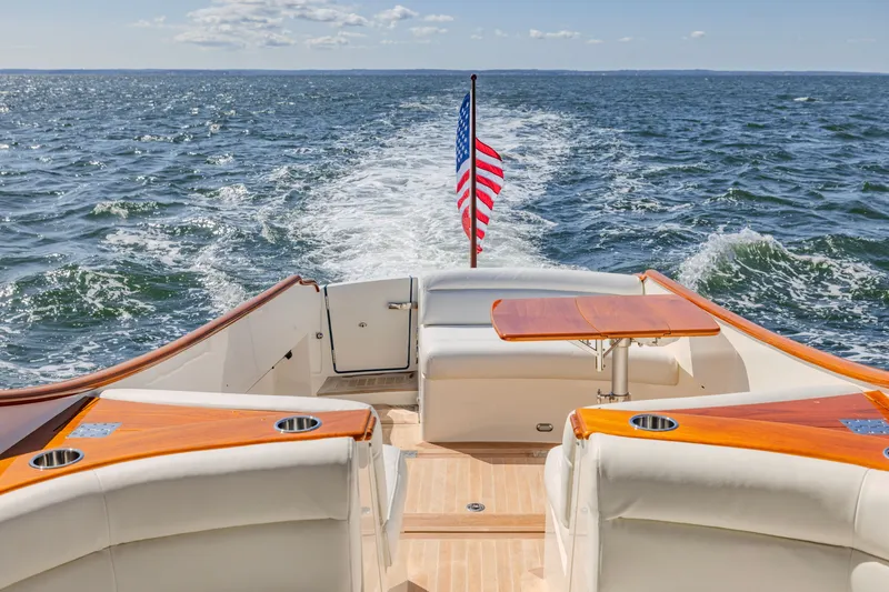 Slide: The Image of Hinckley Picnic Boat 34 MKII cruising on open water, rear view with American flag. - 3