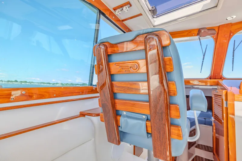Slide: The Image of Interior of 2021 Hinckley Picnic Boat 34 MKII with wooden and blue leather seating. - 11