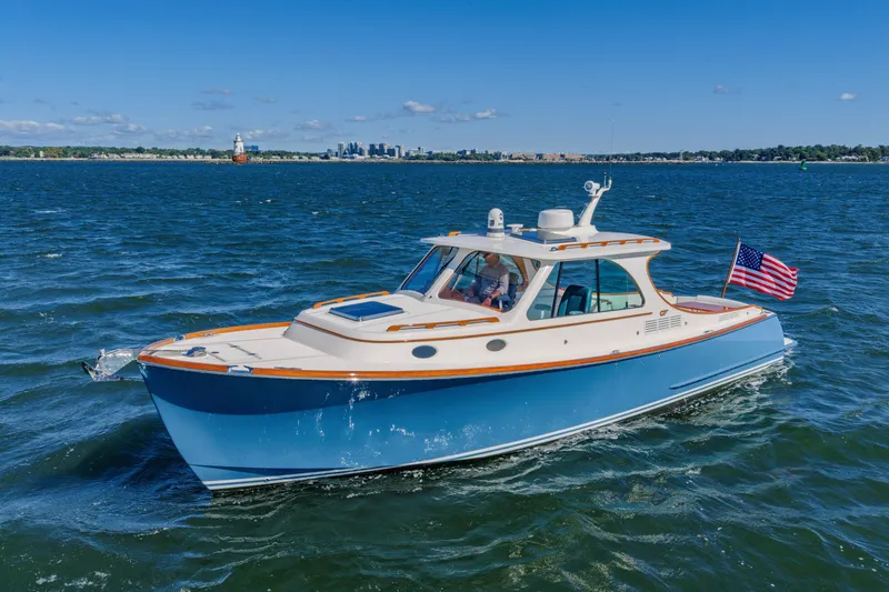 Slide: The Image of 2021 Hinckley Picnic Boat 34 MKII cruising on open water with American flag. - 22
