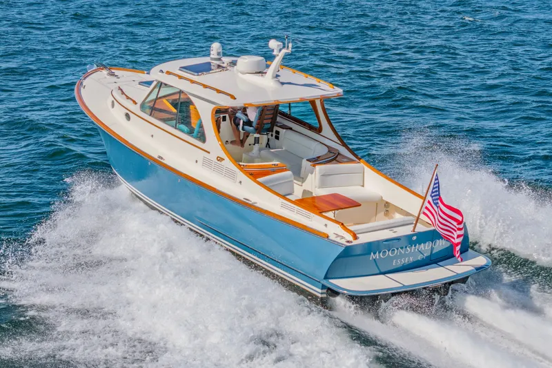 Slide: The Image of 2021 Hinckley Picnic Boat 34 MKII cruising on open water, displaying American flag. - 2