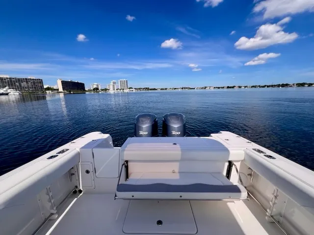 Slide: The Image of The image shows the stern of an Edgewater 320CC boat on calm water with two engines. - 23