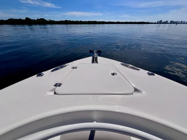 Slide: The Image of The 2018 Edgewater 320CC features a clear bow view on calm waters under a blue sky. - 5