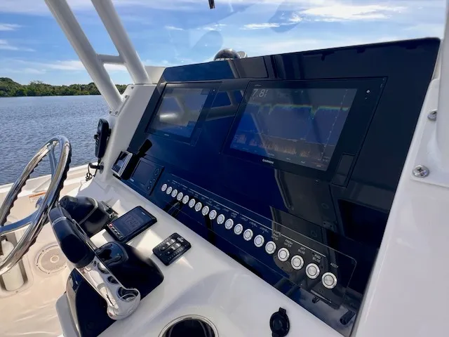Slide: The Image of The image shows the cockpit of a 2018 Edgewater 320CC boat with modern instruments. - 33