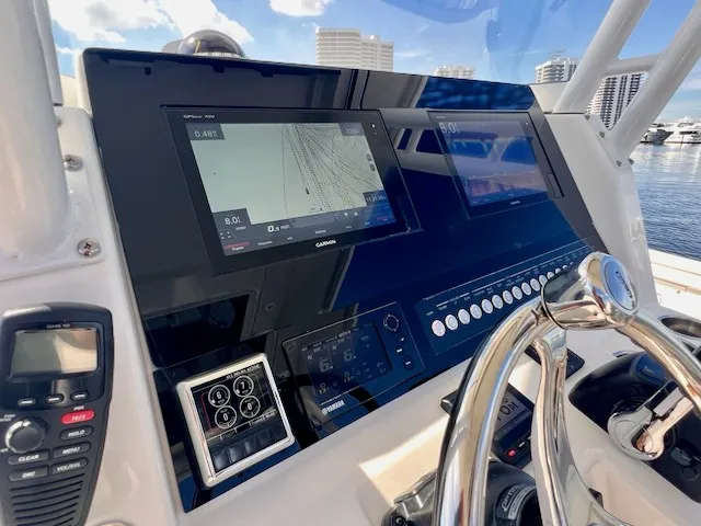 Slide: The Image of The image shows the cockpit of a 2018 Edgewater 320CC boat with modern navigation systems. - 34