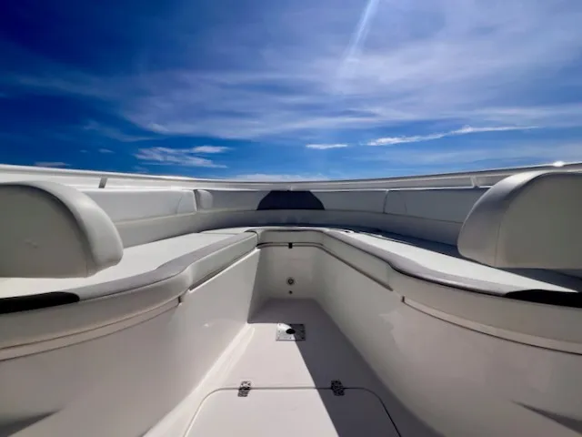 Slide: The Image of The image shows the bow area of a 2018 Edgewater 320CC boat under a clear blue sky. - 8