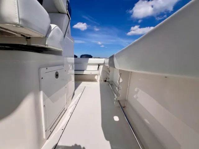 Slide: The Image of The image shows the deck of a 2018 Edgewater 320CC boat under a clear blue sky. - 38