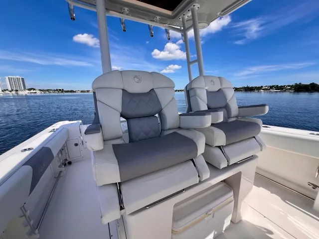 Slide: The Image of Two luxurious captain's chairs on an Edgewater 320CC boat, overlooking calm water and blue sky. - 27