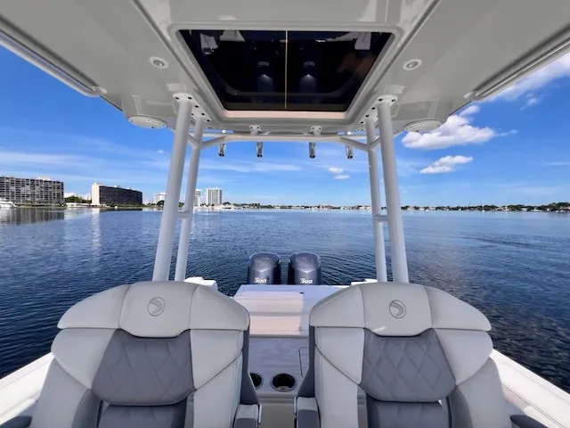 Slide: The Image of The image shows the cockpit of a 2018 Edgewater 320CC boat overlooking the water. - 26