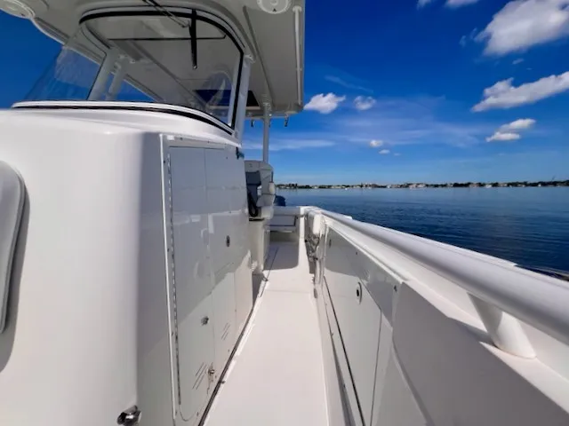 Slide: The Image of A 2018 Edgewater 320CC on calm water. The boat features a sleek, modern design. - 42