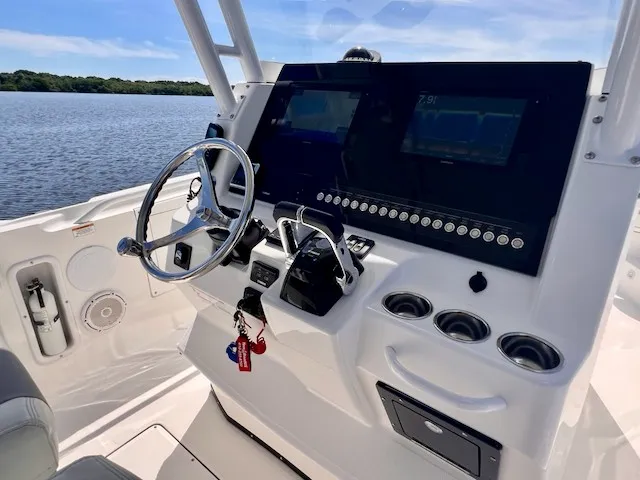 Slide: The Image of The image shows the helm of a 2018 Edgewater 320CC boat with modern instruments. - 32