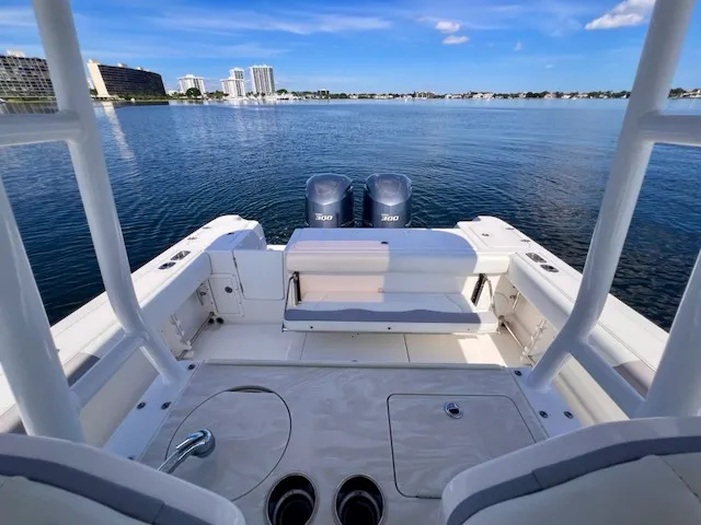Slide: The Image of The image shows the stern of a 2018 Edgewater 320CC boat on calm water. - 24