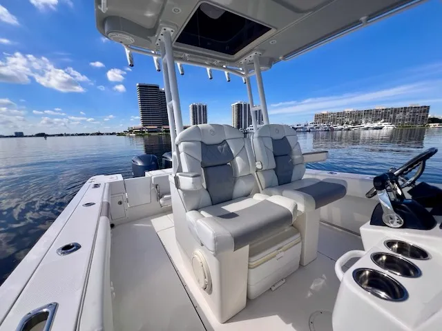 Slide: The Image of The image shows a 2018 Edgewater 320CC boat with luxurious seating and a clear sky. - 49