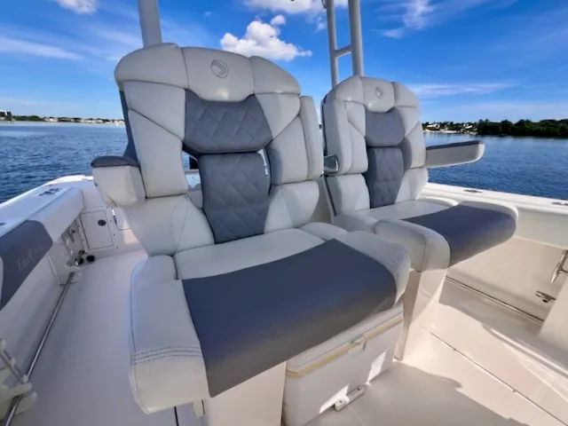 Slide: The Image of Two luxurious, cushioned seats on an Edgewater 320CC boat, overlooking calm waters. - 28