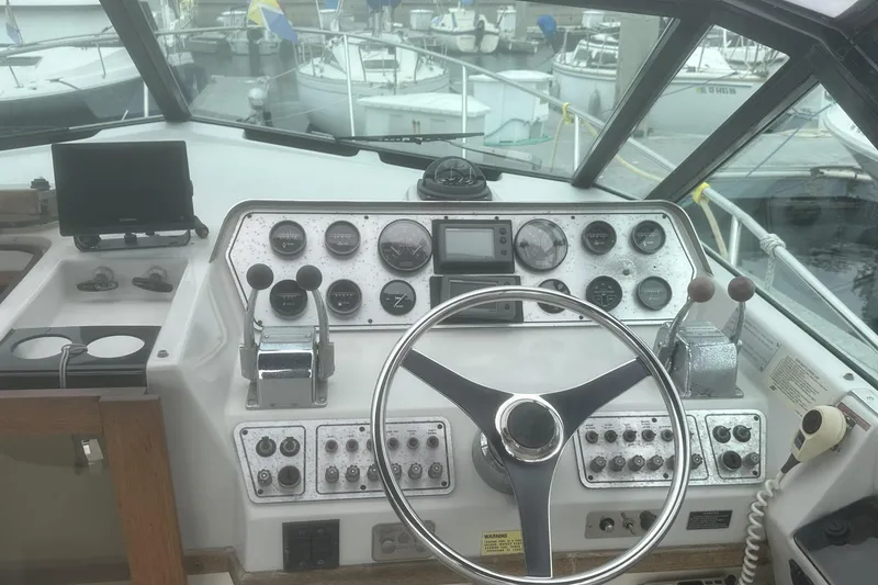 Slide: The Image of 1985 Tiara 2700 Continental boat dashboard with steering wheel and control panel. - 11