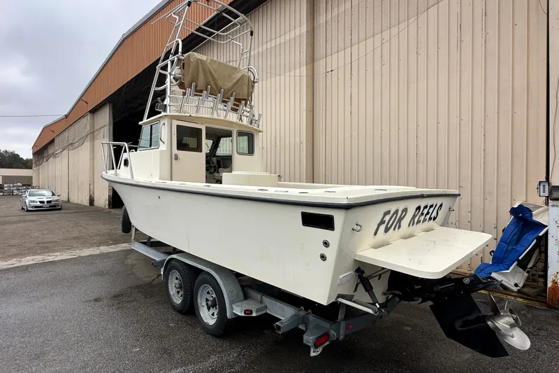 Slide: The Image of 2003 Parker 2520 Deep Vee Sport Cabin boat on trailer near warehouse. - 3
