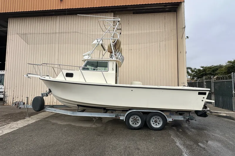 The Image of 2003 Parker 2520 Deep Vee Sport Cabin boat on trailer, parked outside warehouse. - 0