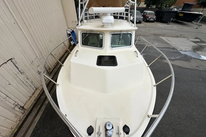 Slide: The Image of 2003 Parker 2520 Deep Vee Sport Cabin boat docked near a warehouse. - 5