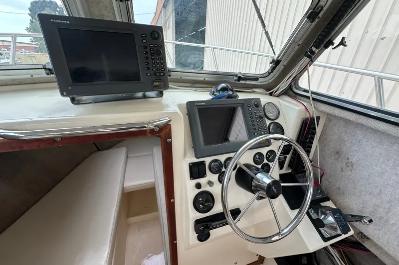 Slide: The Image of 2003 Parker 2520 Deep Vee Sport Cabin helm with navigation equipment and steering wheel. - 16