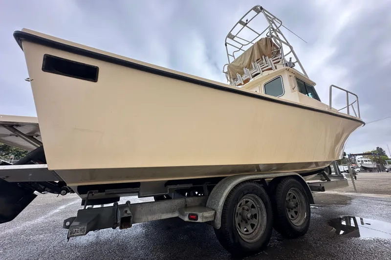 Slide: The Image of 2003 Parker 2520 Deep Vee Sport Cabin boat on trailer, overcast sky background. - 22
