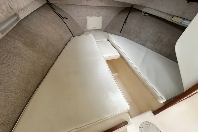 Slide: The Image of 2003 Parker 2520 Deep Vee Sport Cabin interior with cushioned seating and storage space. - 17