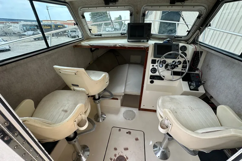 Slide: The Image of 2003 Parker 2520 Deep Vee Sport Cabin interior with helm, seating, and navigation equipment. - 13