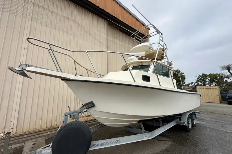 Slide: The Image of 2003 Parker 2520 Deep Vee Sport Cabin boat on trailer, parked outdoors. - 2