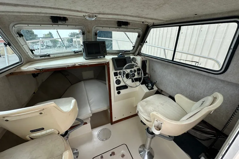 Slide: The Image of Interior of a 2003 Parker 2520 Deep Vee Sport Cabin boat with helm and seating. - 12