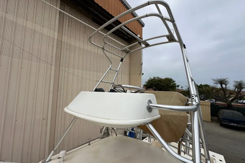 Slide: The Image of 2003 Parker 2520 Deep Vee Sport Cabin boat with aluminum tower, docked near a building. - 18