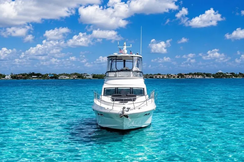 Slide: The Image of 2008 Sea Ray 47 Sedan Bridge yacht on clear blue water under a sunny sky. - 2