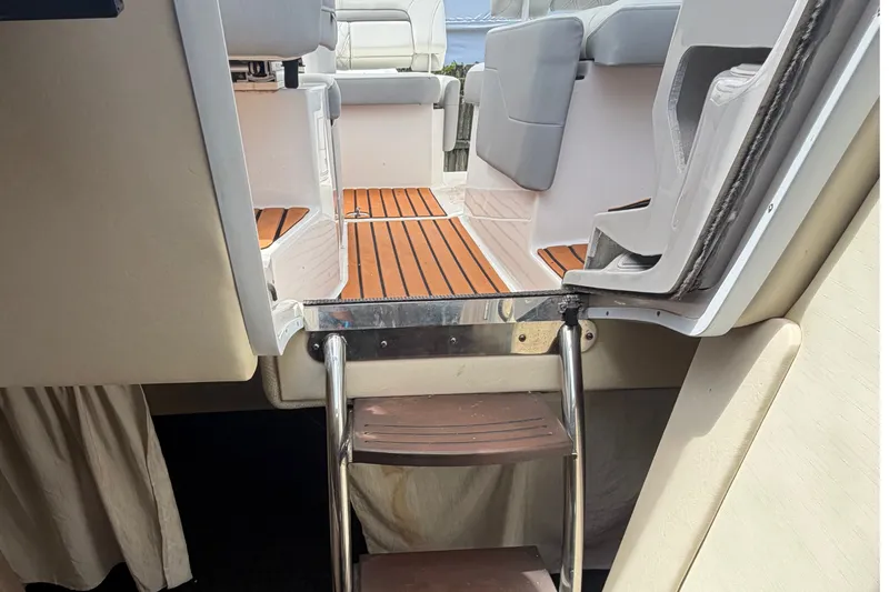 Slide: The Image of 2023 Regal 26 XO boat interior with wooden flooring and cushioned seating. - 9