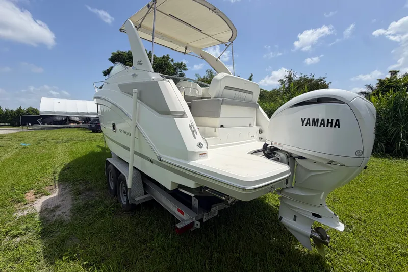 Slide: The Image of 2023 Regal 26 XO boat with Yamaha engine on a trailer, parked on grass. - 18