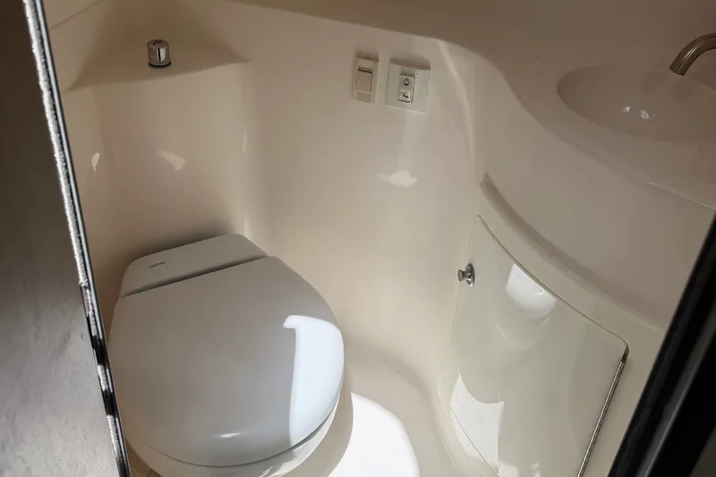 Slide: The Image of 2023 Regal 26 XO boat bathroom with toilet and sink, compact and modern design. - 12