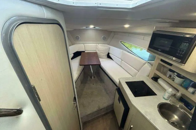 Slide: The Image of 2023 Regal 26 XO cabin interior with kitchenette, seating, and table. - 10