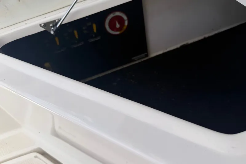 Slide: The Image of Open storage compartment on 2023 Regal 26 XO boat, featuring control panel. - 6