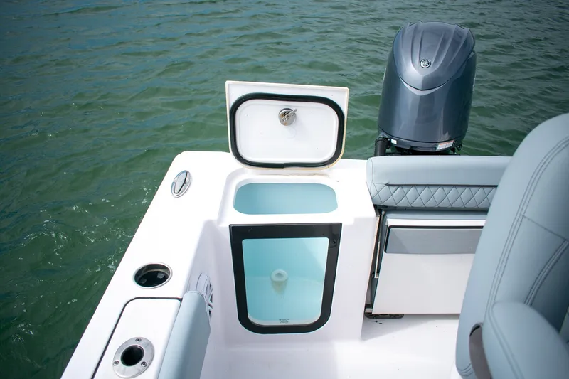 Slide: The Image of 2026 Sportsman Open 212 Center Console boat with open storage compartment and outboard motor. - 16