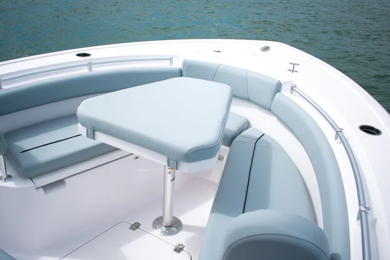 Slide: The Image of 2026 Sportsman Open 212 Center Console boat with cushioned seating and table on calm water. - 10