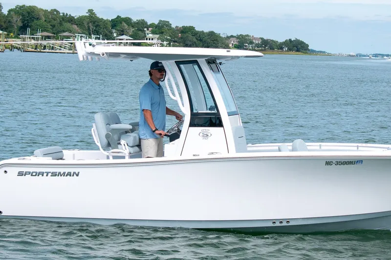 Slide: The Image of 2026 Sportsman Open 212 Center Console boat cruising on a scenic waterway. - 1
