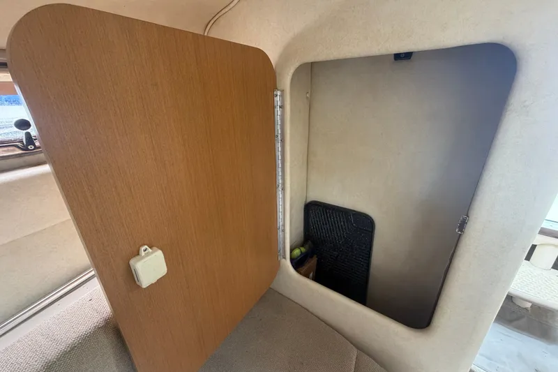 Slide: The Image of Interior cabin storage of 2009 Sea Ray 240 Sundancer boat, featuring open wooden door. - 75