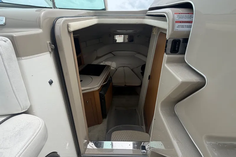 Slide: The Image of 2009 Sea Ray 240 Sundancer cabin interior with seating and compact kitchenette. - 55
