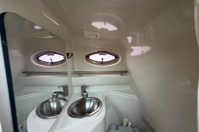 Slide: The Image of Interior of 2009 Sea Ray 240 Sundancer boat bathroom with sink and porthole window. - 80