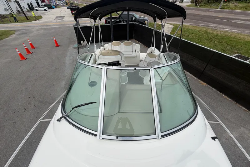 Slide: The Image of 2009 Sea Ray 240 Sundancer boat with canopy, docked on a paved area. - 51