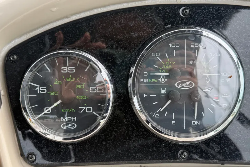 Slide: The Image of Dashboard gauges of a 2009 Sea Ray 240 Sundancer boat, showing speed and engine metrics. - 40