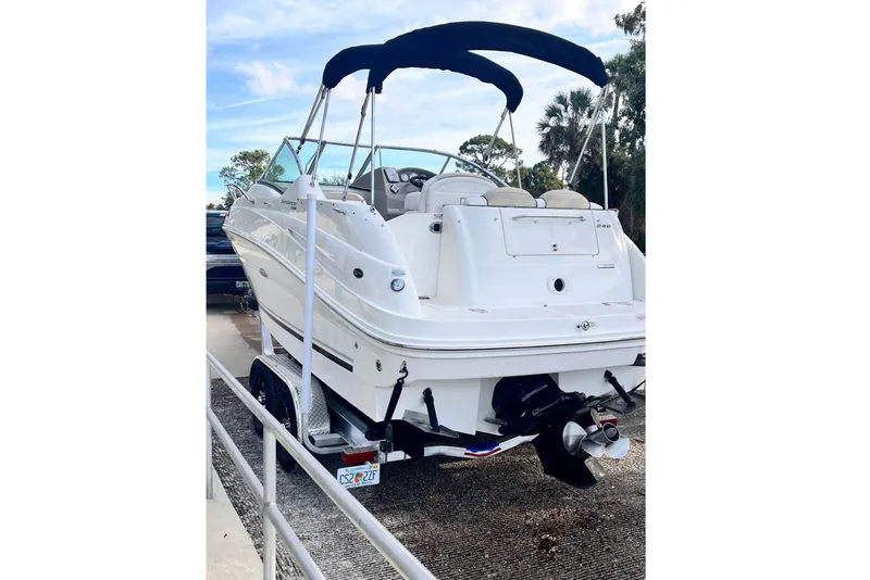 Slide: The Image of A white 2009 Sea Ray 240 Sundancer boat on a trailer. It features a black canopy. - 3