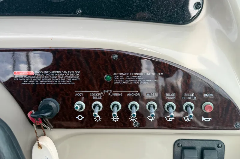 Slide: The Image of Control panel of a 2009 Sea Ray 240 Sundancer boat with various switches and warnings. - 15