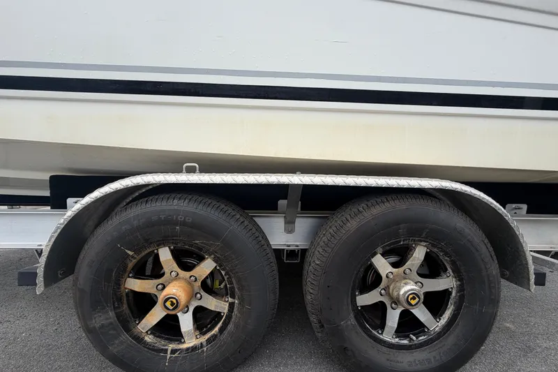 Slide: The Image of Trailer wheels of a 2009 Sea Ray 240 Sundancer boat on pavement. - 104